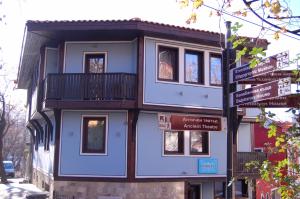 ein blaues Gebäude mit Balkon an einer Straße in der Unterkunft Hotel Evmolpia in Plowdiw