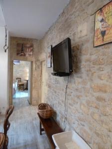 サルラ・ラ・カネダにあるAppartement centre médiéval - Le Cosy de Sarlatの石壁のリビングルーム(テレビ付)