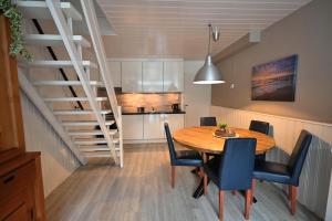 a kitchen and dining room with a table and a staircase at Woeste Hoeve 112 in Biggekerke