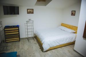 a bedroom with a white bed and a television at Ungweiser in Uzhhorod