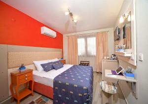 ein Schlafzimmer mit einem Bett und einer roten Wand in der Unterkunft Dions hotel in Seferihisar