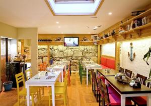 ein Restaurant mit Tischen und Stühlen und einem Fernseher an der Wand in der Unterkunft Dions hotel in Seferihisar