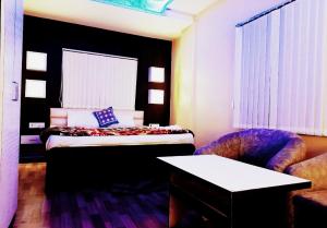 a hotel room with a bed and a chair at royal galaxy hotel in Durgāpur