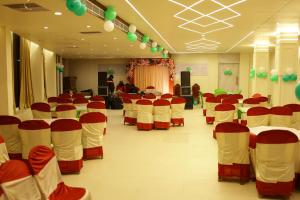 a banquet hall with red and white tables and chairs at royal galaxy hotel in Durgāpur