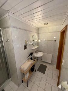 a white bathroom with a sink and a mirror at Pferdehof Almgut - Reiten für Kinder, Natur und Erholung nahe Salzburg in Faistenau +33 photos