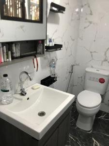 a bathroom with a white sink and a toilet at Smiley Bungalows Guesthouse in Srithanu