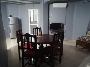 a dining room with a table and chairs and a television at Les 4 chemins in Bejaïa +1 photo