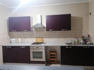a kitchen with purple cabinets and a stove top oven at Les 4 chemins in Bejaïa