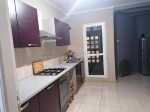 a kitchen with purple cabinets and a stove top oven at Les 4 chemins in Bejaïa