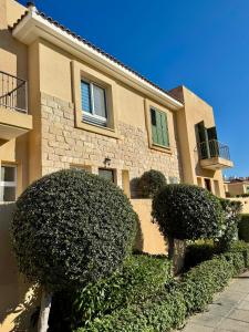 a large house with bushes in front of it at Polis Gardens Pool Apartment in Polis Chrysochous