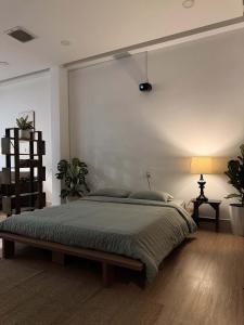 a bedroom with a large bed and a white wall at Ceilé Stay Đà Lạt in Da Lat