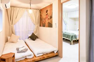 a bedroom with two beds and a mirror at Court Ada -1min to Araiyakushi-mae Station, 9min train to Shinjuku- 新井薬師前駅徒歩50秒 in Tokyo