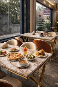 a group of tables with plates of food on them at FairMounts Plaza Inns Near Delhi International Airport in New Delhi
