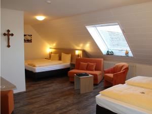 a room with two beds and a chair and a window at Hotel Engel in Kappel-Grafenhausen