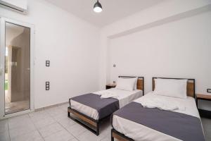 a bedroom with two beds and a mirror at Villa Pasiphae by PosarelliVillas in Vamos +16 photos