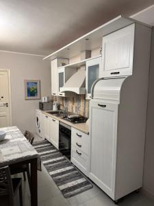 a kitchen with white cabinets and a stove top oven at House S&D in Giarre