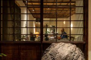 a reflection of a man in a window at ZenHome by M2 in Hoi An