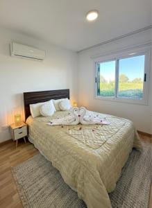 a bedroom with a large bed with a large window at Polis Gardens Pool Apartment in Polis Chrysochous +18 photos
