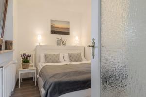 a white bedroom with a bed in a room at Dünensand in Süderende
