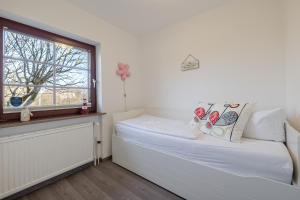 a small bedroom with a bed and a window at Robbennest in Süderende