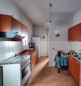 a kitchen with wooden cabinets and a white refrigerator at B&B Palazzo Antonelli in Monopoli
