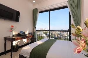a bedroom with a bed and a large window at APT Hotel Phan Rang in Phan Rang–Tháp Chàm