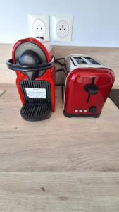 a red toaster sitting on top of a wooden floor at Studio LY'S in Saint-François