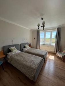ein Schlafzimmer mit zwei Betten, einer Couch und einem Fenster in der Unterkunft AgroKrówka - Agroturystyka w Niecieczy in Nieciecza