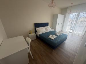a bedroom with a bed and a table and a desk at Vale House in Monopoli