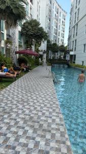 a swimming pool in the middle of a building at City Garden Olympus Premier By Vacation Vibes in Pattaya South