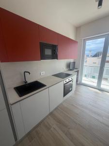 a kitchen with a sink and a microwave at Vale House in Monopoli