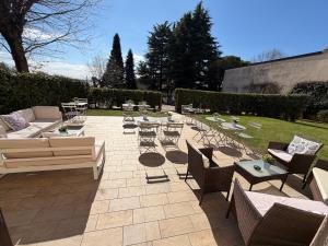 a patio with couches and tables and chairs at Corte Al Lago in Moniga