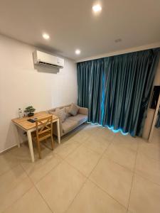 a living room with a couch and a table at City Garden Olympus Premier By Vacation Vibes in Pattaya South