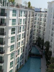 an apartment building with a swimming pool in front of it at City Garden Olympus Premier By Vacation Vibes in Pattaya South