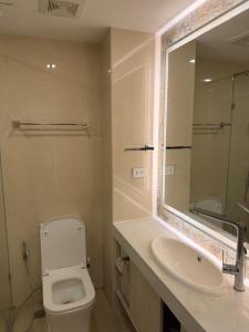 a bathroom with a toilet and a sink and a mirror at City Garden Olympus Premier By Vacation Vibes in Pattaya South +9 photos