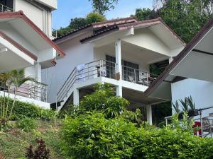 ein weißes Gebäude mit Balkon und Bäumen in der Unterkunft BRW Samui in Bophut 