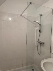 a shower with a glass door next to a sink at Fossewold Cotswold Barn in Chipping Campden