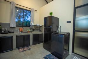 a kitchen with a large black refrigerator in a room at Hill Top Legacy in Ambalangoda +47 photos