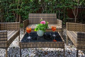 two chairs and a table with a potted plant and two glasses at B&B Villa Regina in Pisa