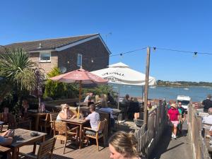 a group of people sitting at tables at a restaurant at Beach House Manningtree in Manningtree
