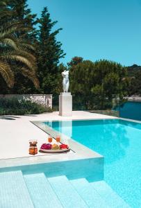 a pool with a plate of food next to a statue at Villa Mila in Selca