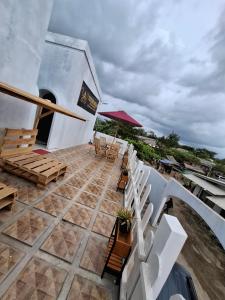 a balcony with chairs and tables on a building at YouYouKe Pavillon Karangpapak in Cilauteureun