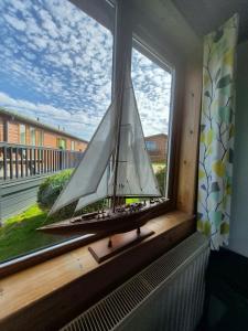 a model boat sitting on a window sill at 3-Bed Ocean View Lodge - Parking & Terrace in Ilfracombe