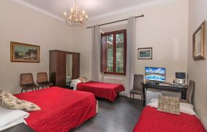 a bedroom with two beds and a desk and a television at B&B Villa Regina in Pisa