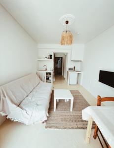 a white living room with a couch and a table at Sand & Sea II in Neo Klima