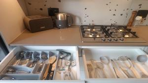 a kitchen with a stove and a drawer full of utensils at NEW BOSTON in Bellville +13 photos