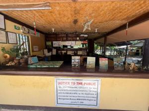 a ticket counter in a restaurant with a notice to the public at High Chaparral Cottages in El Nido