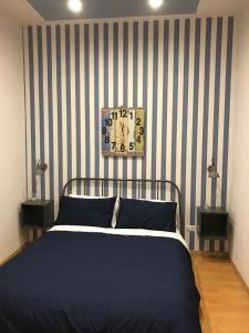 um quarto com uma cama com uma parede listrada em La Maison em Manfredónia