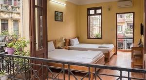 two beds in a room with a balcony at Con Vanh Hotel in Bằng Viên
