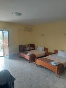 a room with two beds in a room with a window at Porto Lagos Rooms in Lágos
